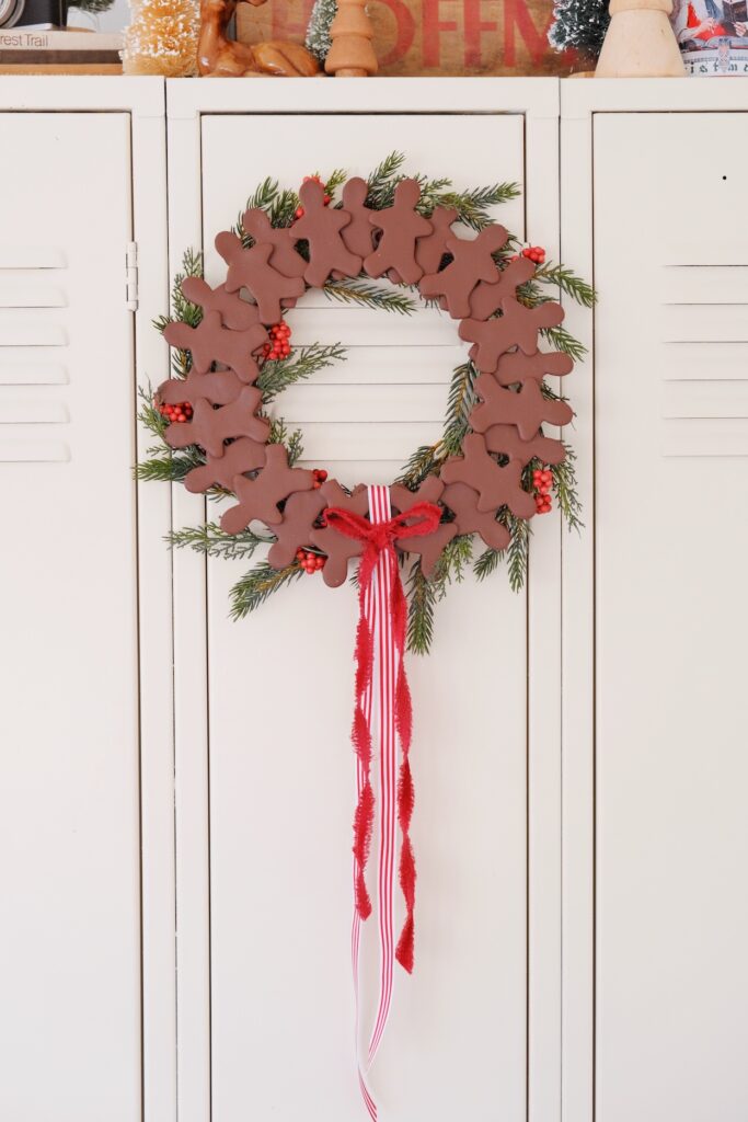 Wreath with clay Gingerbread men, faux greenery, and ribbon